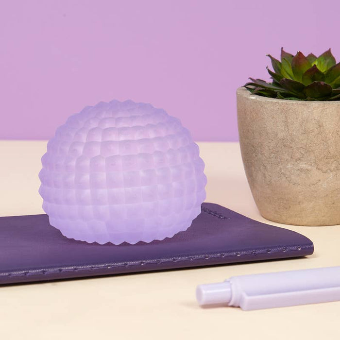 Hands holding and squeezing the Memory Gel Stress Ball, demonstrating memory gel bounce-back