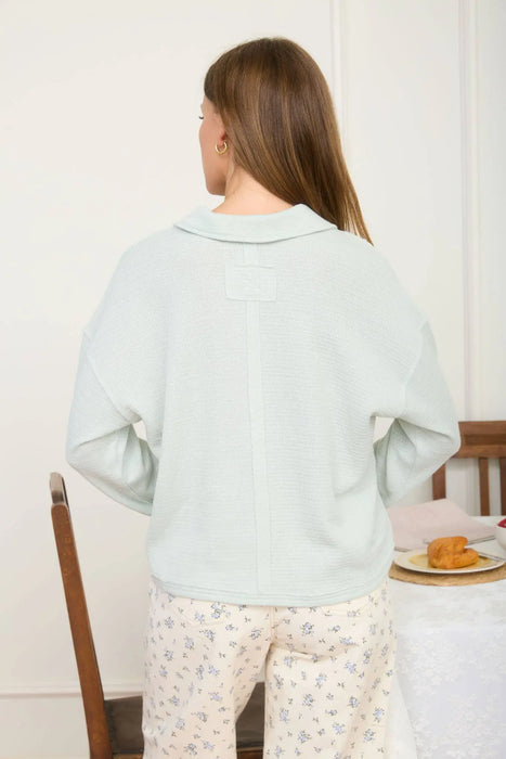 Women’s long sleeve knit polo with textured fabric and modern exposed seam accents