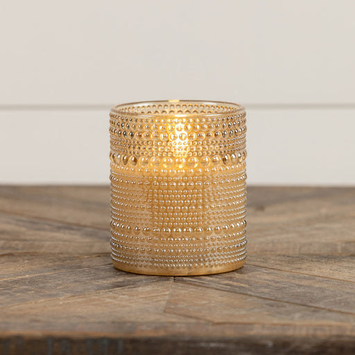 Close-up of champagne gold dotted glass texture on battery-operated flameless LED candle