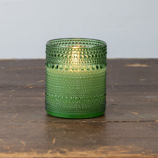 Close-up of green dotted glass texture on battery-operated flameless candle