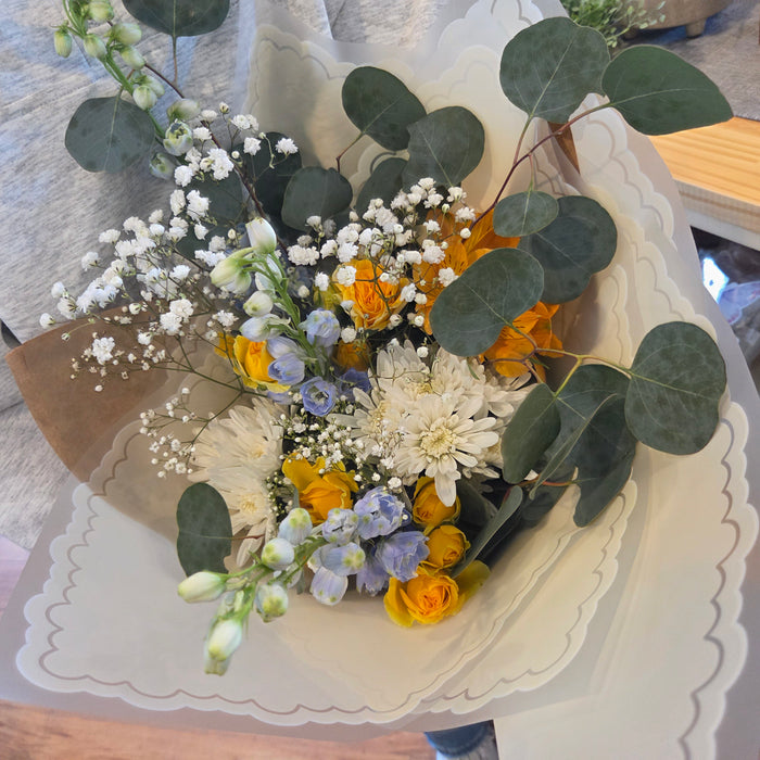 Spring fresh flowers arranged in pastel blue yellow and white tones close up