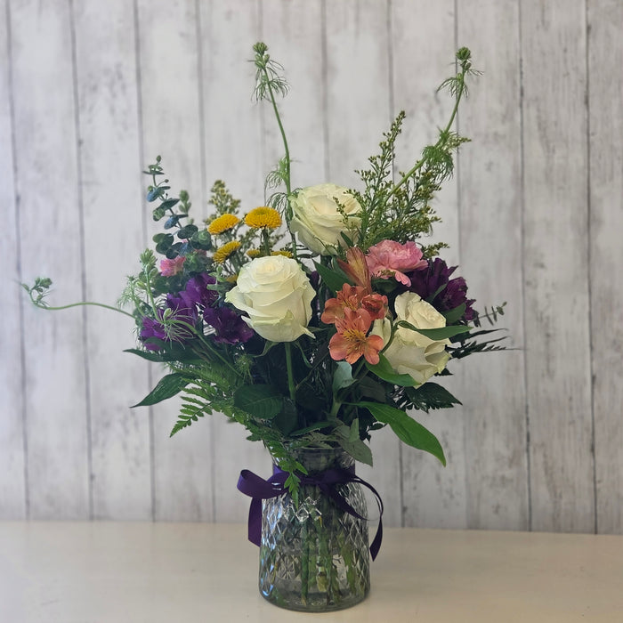 Fresh seasonal flower arrangement in vase with roses, carnations, and eucalyptus at Heartland Store MN
