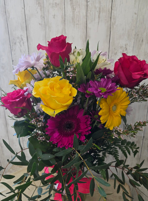Close-up of yellow and lavender flowers with greenery in a seasonal vase arrangement from Heartland Store Minnesota
