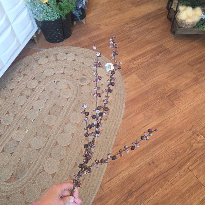 Faux burgundy berry stems arranged in outdoor basket in Minnesota home