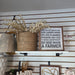Faux beige eucalyptus leaf branch styled in a neutral farmhouse entryway vignette