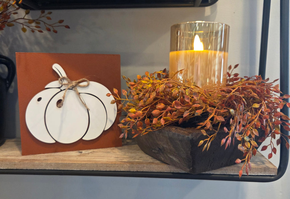 Close-up view of artificial rust orange berries on candle ring highlighting realistic fall colors and craftsmanship