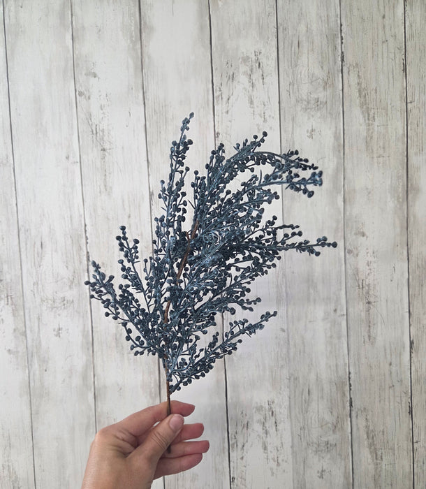 Close-up of faux blue berries on a single artificial stem – realistic texture for fall and winter decorating