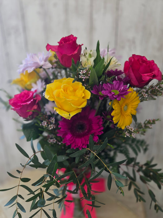 Picture of a fresh yellow and purple flower arrangement with eucalyptus displayed at Heartland Store MN