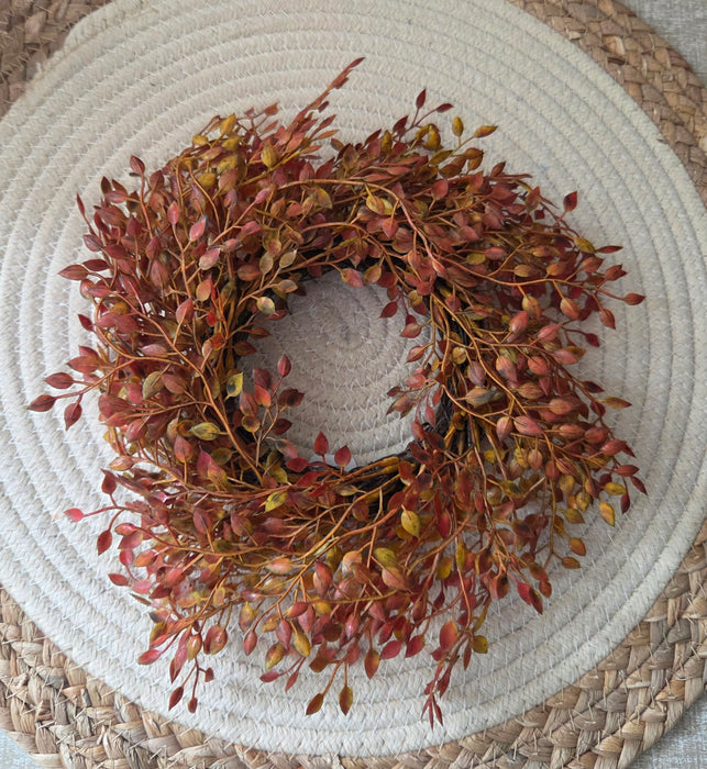 Rust orange berry candle ring lifestyle shot showing how it fits around standard pillar candle or decorative peice for fall decor