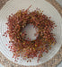 Rust orange berry candle ring lifestyle shot showing how it fits around standard pillar candle or decorative peice for fall decor